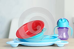 Set of plastic dishware on wooden table. Serving baby food