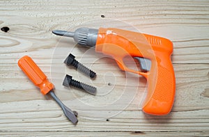 Set of plastic toy tools over wooden