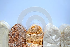 A set of plastic transparent bags with cereals on a blue background. Donations.