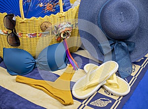 Beach accessories on pastel backgrounds-glasses, hat, towel, flip flops, fan, sunscreen, bag and bikini