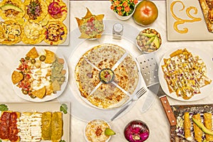 Set of popular Mexican dishes. Synchronized quesadillas, nachos with guacamole, golden tacos, assorted tacos, aguacate, guacamole