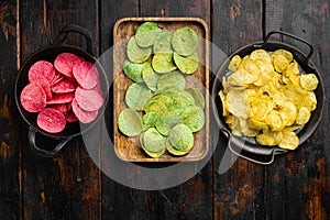 Set potato chips on old dark  wooden table background, top view flat lay