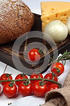 A set of products from fresh, crisp bread, cheese, onions and cherry tomatoes on the table before cooking