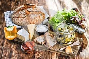 Set of products for a Mediterranean breakfast: olives, bread, cheeses, herbs and vegetables