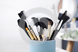 Set of professional makeup brushes in holder, closeup