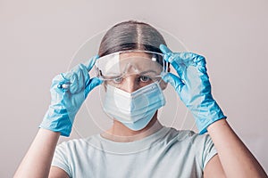 Set of protective eqipment agains viruses - chirurgical mask, gloves and glasses on lab technician worker