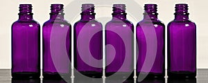 Set of purple cosmetic bottles on the makeup table