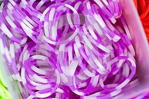 A set of purple elastic bands for weaving bracelets for children.