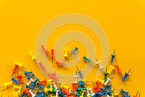 Set of push pins in different colors. Thumbtacks. Top view. on Yellow background