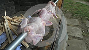 Set of rare chicken pulled on stainless grilling bar wait for a tie in exact possition for frying