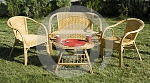 Set of rattan furniture on green grass in the yard