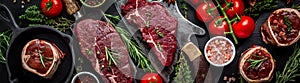 Set raw beef steaks on over meat butcher knife with spices dark background. Close up. Long banner format, top view