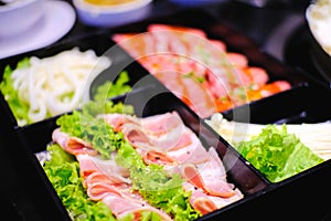 Set of raw sliced meat pork beef and vegetable on black plate