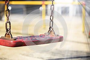 Set of red chain swings on modern kids playground