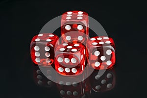 Set of red game cubes, on a black background, with reflection