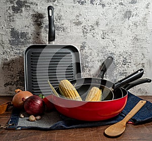 a set of red pans with vegetables