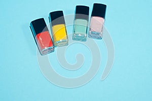 Set of red, pink, green and yellow. nail polish. Make up beauty products on blue background. Decorative cosmetics. Top view, flatl