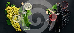 Set of red and white wine in bottles and glasses. Grape. On a black wooden background. Free space for text.