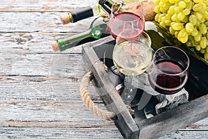 Set of red and white wine in bottles and glasses. Grape. On a white wooden background. Free space for text.