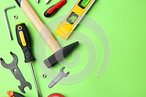 Set of repair tools on light green background,  lay. Space for text