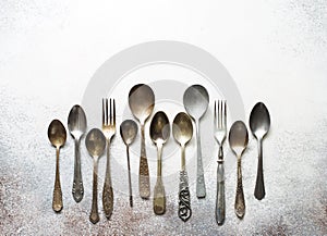 Set of retro spoons and forks on gray stone background