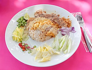 Set of rice with mas fried in batter on a white plate with slices of pineapple, onion, cucumber