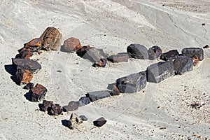 A set of rocks in the shape of a heart in the dried mud