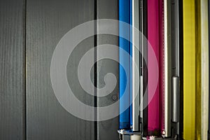 Set of rollers in color laser printer ink cartridges on wooden background