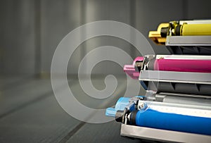 Set of rollers in color laser printer ink cartridges on wooden background