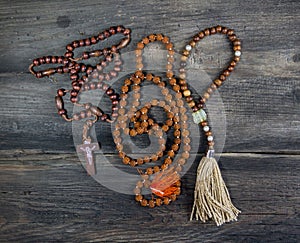 set of rosaries of various religions on rustic wood