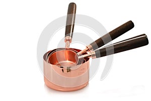 Set of rose gold measuring cups with wooden handle