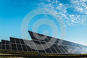 set of rows of solar panels under blue sky, in solar photovoltaic plant