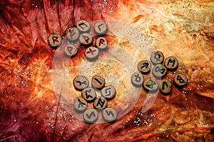 Set of runes divided into aetts on mottled colorful fabric photo