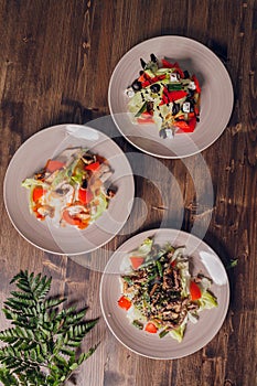 Set of salads on a dark background. Greek salad, Caesar salad, vegetable salad.