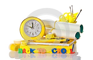 Set of school supplies, an alarm clock and an inscription back to school, isolated on white