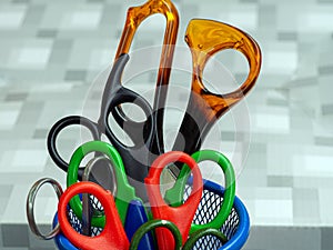 A set of scissors of different sizes in the stand.