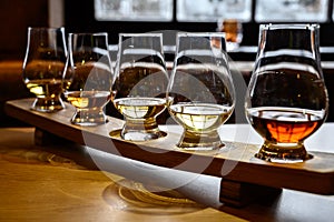 Scotch whisky, tasting glasses with variety of single malts or blended whiskey spirits on distillery tour in Scotland photo