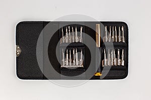 a set of screwdrivers in a leather case on a white background