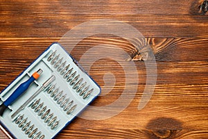 Set of screwdrivers with nozzles on a wooden background. Copy space and top view