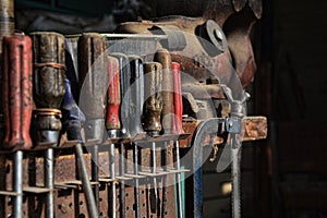 A set of screwdrivers, saws, vice, and other work tools in an old workshop