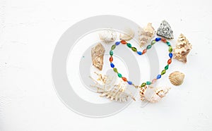 Set of seashells, pearls and stones in form heart