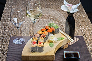 Set of several different rolls on a wooden stand on a table in a Japanese restaurant. Japanese traditional sushi and