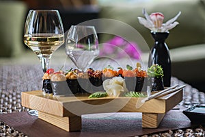 Set of several different rolls on a wooden stand on a table in a Japanese restaurant. Japanese traditional sushi and