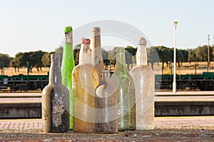 Un conjunto compuesto por viejo sucio botellas de diferente tipos de alcohólico bebidas sobre el de viejo sobre el el tren estación 