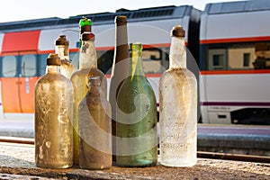 Un conjunto compuesto por viejo sucio botellas de diferente tipos de alcohólico bebidas sobre el de viejo sobre el el tren estación 