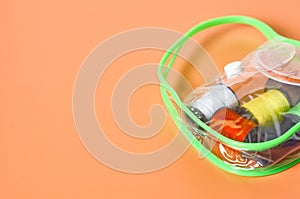 Set of sewing accessories in transparent plastic handbag lies on orange tailors desk in workshop