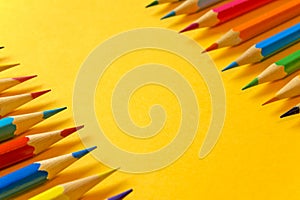 Set of sharpened colored pencils on a yellow background