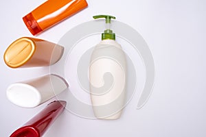 A set of shower products in colorful plastic bottles for bodycare on white background, beauty routine concept with copy space