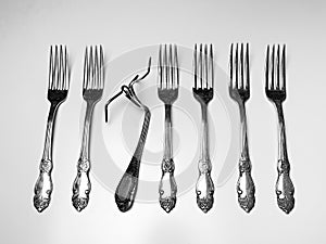 Set of silver antique forks with one deformed fork isolated on white background