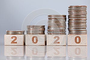 Set of silver coins standing at wooden bricks in growing order